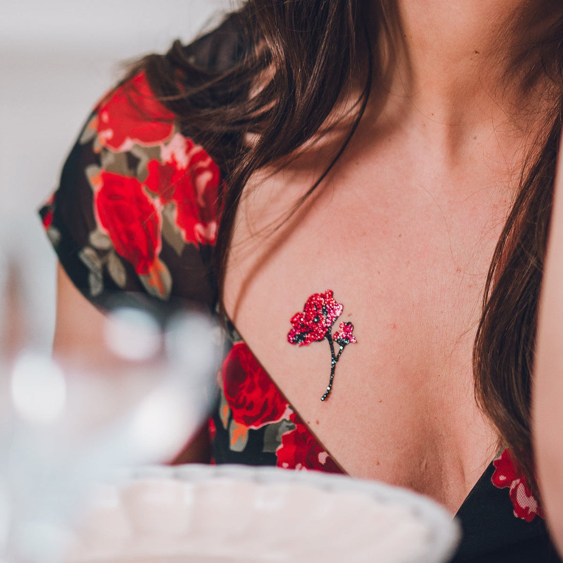Love Poppy rouge, bijou de peau M Paris porté sur le décolleté